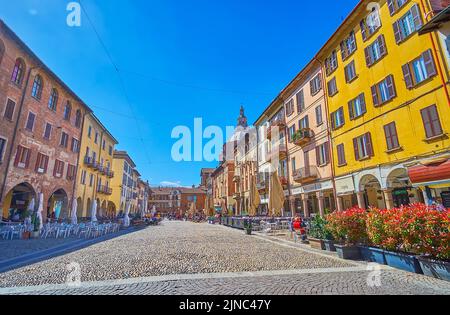 PAVIA, ITALIEN - 9. APRIL 2022: Piazza della Vittorio, auch bekannt als Piazza Grande mit schönen mittelalterlichen Villen und Palästen, am 9. April in Pavia, Es Stockfoto