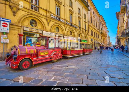 PAVIA, ITALIEN - 9. APRIL 2022: Die Touristenbahn auf der Corso Strada Nuova Straße in der Altstadt, am 9. April in Pavia, Italien Stockfoto