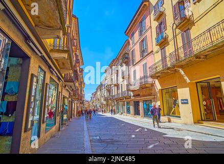 PAVIA, ITALIEN - 9. APRIL 2022: Spaziergang entlang der Corso Strada Nouva Straße zwischen historischen Gebäuden mit Geschäften und Cafés, am 9. April in Pavia, Stockfoto