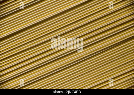 Italienische gesunde Lebensmittel Hintergrund, rohe Spinat Spaghetti füllen den Rahmen in einem strukturierten Design von grünen diagonalen Pasta-Linien. Stockfoto
