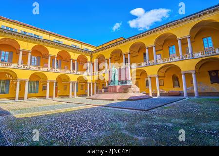 PAVIA, ITALIEN - 9. APRIL 2022: Der helle Innenhof mit Arkaden am Rande des Komplexes der Universität von Pavia, am 9. April in Pavia, Italien Stockfoto