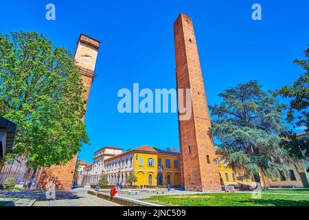 PAVIA, ITALIEN - 9. APRIL 2022: Die bedeutendsten Sehenswürdigkeiten der historischen Stadt Pavia sind die mittelalterlichen Türme, die sich auf der Piazza Leonardo da Vinci, Stockfoto