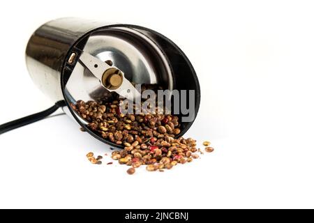 Ganze getrocknete, nicht gemahlene Sumac-Beeren in einem über Gewürzmühle gekippt Stockfoto