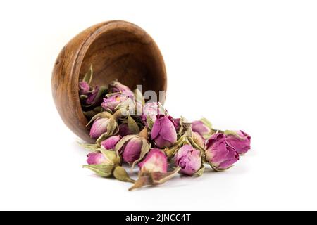 Aus einer kleinen Holzschüssel tropfenarme Rosenknospen Stockfoto