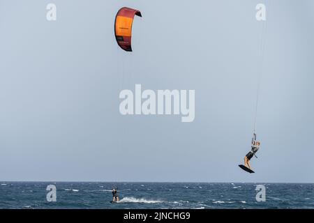 El Medano, Teneriffa, Spanien. 26.. Juli 2022. Kitesurfer gesehen Reiten am Strand von El Medano, auf Teneriffa. Die wichtigsten Hotspots auf Teneriffa, auf den Kanarischen Inseln, füllen sich im Sommer mit Touristen. (Bild: © Hugo Amaral/SOPA Images via ZUMA Press Wire) Stockfoto