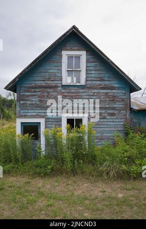 Altes verlassenes zweistöckiges Haus auf einem Feld. Stockfoto