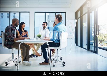 Das nennen Sie ein produktives Umfeld. Eine Gruppe junger Geschäftsleute diskutiert bei einem Treffen in einem modernen Büro miteinander über Ideen. Stockfoto