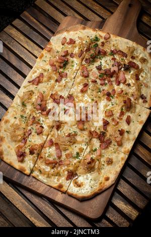 Flammkuchen tarte Flambee rechteckige Pizza mit Speck und Huhn auf Holztisch Hintergrund Stockfoto