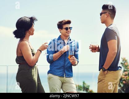 Wir haben immer die besten Zeiten zusammen. Eine Gruppe von Freunden trinken und genießen sich im Urlaub im Freien. Stockfoto