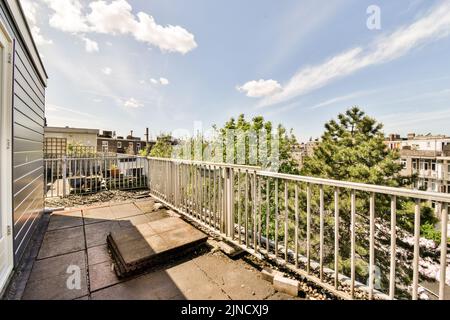 Kleiner gemauerter Balkon mit Metallgeländer und Tür Stockfoto