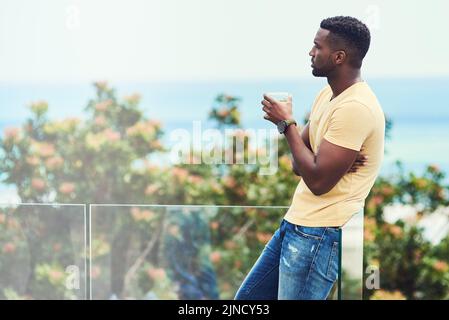 Denken Sie zurück an das lange Jahr, das Ive hatte. Ein hübscher junger Mann, der einen Drink hat, während er sich im Urlaub im Freien entspannt. Stockfoto