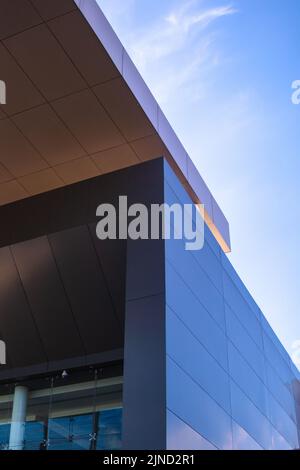 Graues Gebäude mit Himmel im Hintergrund. Architektonische Struktur mit interessanten Komposition Linien Stockfoto