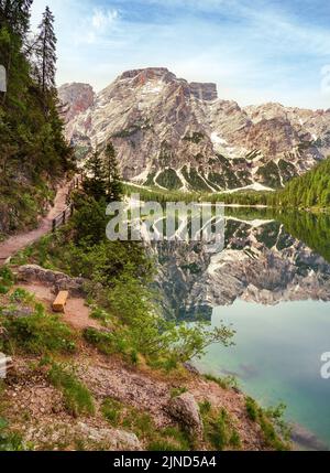 Blick vom Wanderweg am See auf den Seekofel, der sich im klaren Wasser des berühmten Naturgebirgssees Pragser Wildsee (Pragser See) spiegelt Stockfoto