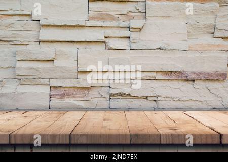 Leerer Holztisch und Muster der dekorativen Schiefersteinwand mit Kopierfläche Stockfoto