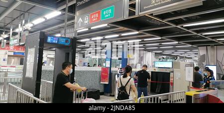 Shenzhen, China: Passagiere, die mit der Hochgeschwindigkeitsbahn nach Shenzhen einreisen, müssen über einen grünen Code für die 48-Stunden-Nukleinsäureerkennung verfügen. A1 das Exit-Personal überprüft den Stockfoto