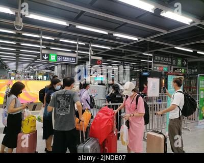 Shenzhen, China: Passagiere, die mit der Hochgeschwindigkeitsbahn nach Shenzhen einreisen, müssen über einen grünen Code für die 48-Stunden-Nukleinsäureerkennung verfügen. A1 das Exit-Personal überprüft den Stockfoto