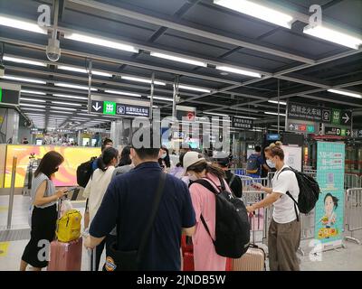 Shenzhen, China: Passagiere, die mit der Hochgeschwindigkeitsbahn nach Shenzhen einreisen, müssen über einen grünen Code für die 48-Stunden-Nukleinsäureerkennung verfügen. A1 das Exit-Personal überprüft den Stockfoto