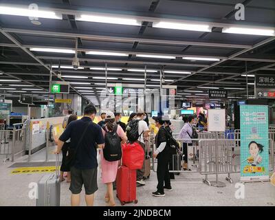 Shenzhen, China: Passagiere, die mit der Hochgeschwindigkeitsbahn nach Shenzhen einreisen, müssen über einen grünen Code für die 48-Stunden-Nukleinsäureerkennung verfügen. A1 das Exit-Personal überprüft den Stockfoto
