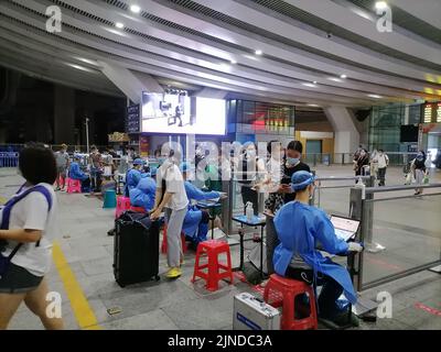 Shenzhen, China: Passagiere, die mit der Hochgeschwindigkeitsbahn nach Shenzhen einreisen, müssen über einen grünen Code für die 48-Stunden-Nukleinsäureerkennung verfügen. A1 das Exit-Personal überprüft den Stockfoto