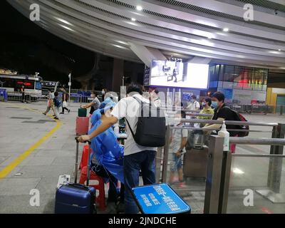 Shenzhen, China: Passagiere, die mit der Hochgeschwindigkeitsbahn nach Shenzhen einreisen, müssen über einen grünen Code für die 48-Stunden-Nukleinsäureerkennung verfügen. A1 das Exit-Personal überprüft den Stockfoto