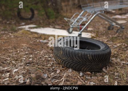 Illegales Abladen von Reifen und anderem Material auf dem Land. Das Konzept der Umweltverschmutzung. Stockfoto