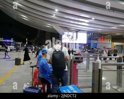 Shenzhen, China: Passagiere, die mit der Hochgeschwindigkeitsbahn nach Shenzhen einreisen, müssen über einen grünen Code für die 48-Stunden-Nukleinsäureerkennung verfügen. A1 das Exit-Personal überprüft den Stockfoto