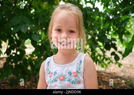 Portrait schöne glücklich Kind Mädchen lächelt während der Sommerzeit im Freien Stockfoto
