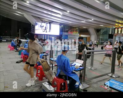 Shenzhen, China: Passagiere, die mit der Hochgeschwindigkeitsbahn nach Shenzhen einreisen, müssen über einen grünen Code für die 48-Stunden-Nukleinsäureerkennung verfügen. A1 das Exit-Personal überprüft den Stockfoto