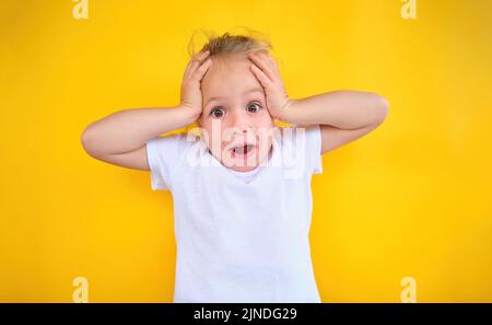 Portrait kleines Mädchen erstaunt überrascht Kind Hände halten Kopf verrückt Ausdruck Stockfoto