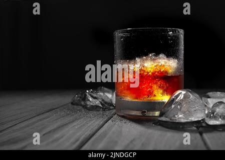 Manhattan auf Eis. Manhattan Whiskey Cocktail auf Eis auf schwarzem Hintergrund mit Stockfoto