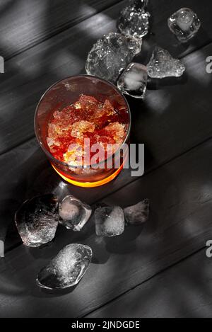 Slushies Whiskey Cocktail mit Eis. Auf schwarzem Hintergrund mit Eiswürfeln Stockfoto