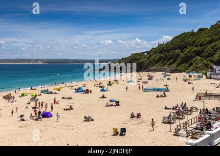 Menschen genießen einen sonnigen Sommertag am Porthminster Beach in St. Ives, Cornwall, England. Stockfoto