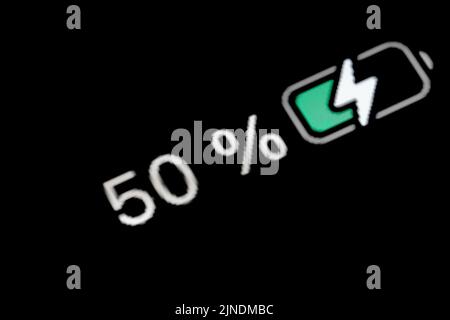 Ladevorgang der Akkustandsanzeige - weiße Zahl - fünfzig, 50 Prozent Stockfoto