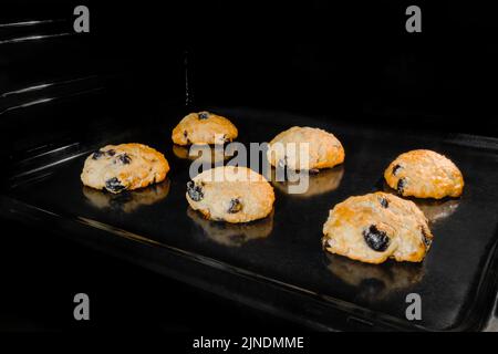 Sechs gebackene hausgemachte knusprige Haferflocken-Plätzchen auf Metallblech im Ofen Stockfoto