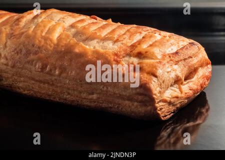 Ein gebackenes hausgemachtes Brötchen mit Apfelmarmelade im Elektroofen: Nahaufnahme Stockfoto