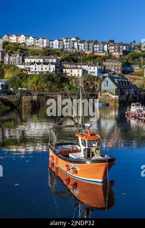 Ein farbenfrohes Fischerboot, das im Innenhafen des kornischen Fischerdorfes Mevagissey festgemacht ist. Stockfoto