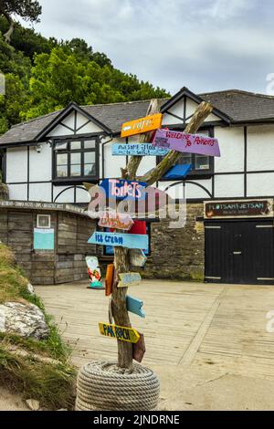 Wegweiser in Polkerris, einer reizvollen sandigen Cornish-Bucht mit einem kleinen Hafen. Stockfoto