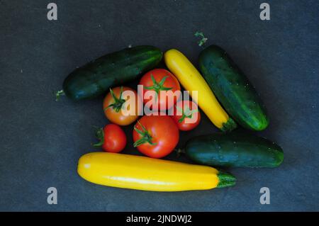 Frisch gepflückte Tomaten, Korgetten und Gurken aus eigenem Anbau Stockfoto