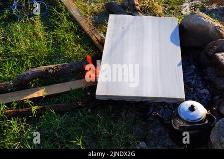 Marmor auf Lagerfeuer zum Kochen und Teekannen am Feuer im Freien Stockfoto