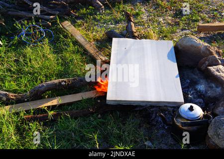 Marmor auf Lagerfeuer zum Kochen und Teekannen am Feuer im Freien Stockfoto