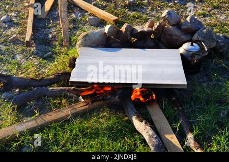 Marmor auf Lagerfeuer zum Kochen und Teekannen am Feuer im Freien Stockfoto