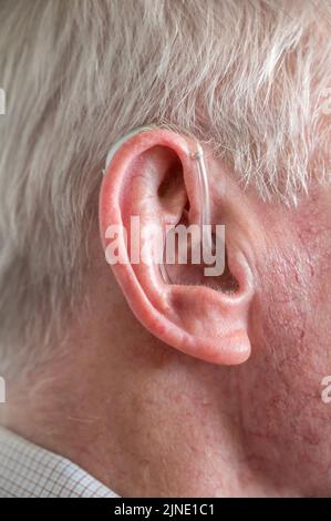 Alter Mann mit modernem Hörgerät im Ohr Stockfoto