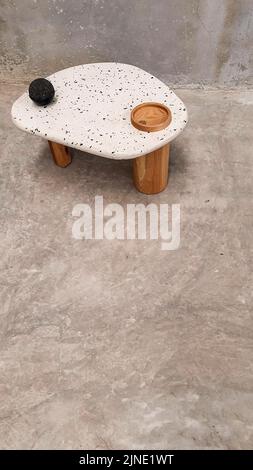 Designer-Couchtisch mit seitlichem oder zentrischem Design, Platte aus Naturstein, Vulkangestein, Steinbruch oder Terrazzo, Basis aus Massivholz Stockfoto