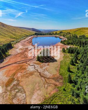 Cantref Reservoir in in Nant-DDU, Cwmtaf, Brecon Beacons Powys, Wales, das von walisischem Wasser gehört, fotografiert von einer Drohne, die zeigt, wie niedrig der Wasserstand gesunken ist. Das Gebiet gehört normalerweise zu den feuchtesten im Vereinigten Königreich und versorgt Cardiff und große Teile von Südwales mit Wasser. Stockfoto