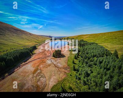 Cantref Reservoir in in Nant-DDU, Cwmtaf, Brecon Beacons Powys, Wales, das von walisischem Wasser gehört, fotografiert von einer Drohne, die zeigt, wie niedrig der Wasserstand gesunken ist. Das Gebiet gehört normalerweise zu den feuchtesten im Vereinigten Königreich und versorgt Cardiff und große Teile von Südwales mit Wasser. Stockfoto