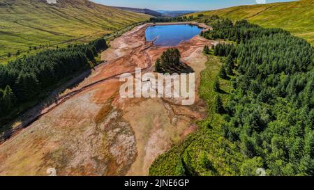 Cantref Reservoir in in Nant-DDU, Cwmtaf, Brecon Beacons Powys, Wales, das von walisischem Wasser gehört, fotografiert von einer Drohne, die zeigt, wie niedrig der Wasserstand gesunken ist. Das Gebiet gehört normalerweise zu den feuchtesten im Vereinigten Königreich und versorgt Cardiff und große Teile von Südwales mit Wasser. Stockfoto