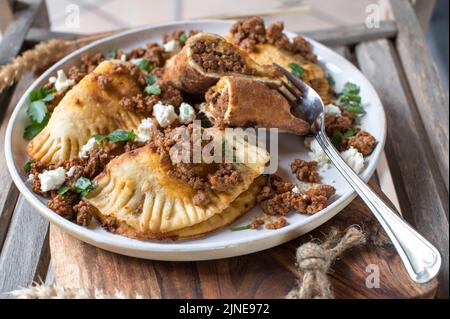 Pierogi, russische Knödel gefüllt mit scharfem Rinderhack und Fetakäse. Stockfoto