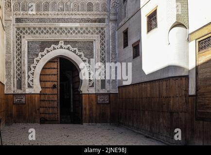 Fez, Marokko - 07. Januar 2020: Eingang zum Nejjarine Museum of Wooden Arts and Crafts, Wand mit komplexen Ornamenten über der Haupttür Stockfoto