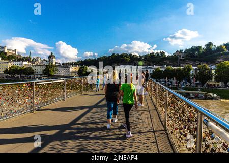 Menschen, die über die Makartsteg-Brücke gehen, die von der Liebe übersät ist, schlössern über die Salzach, Salzburg, das Salzburger Land, Österreich, Europa Stockfoto