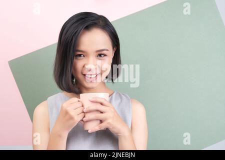 Porträt einer ziemlich lächelnden jungen Frau mit einer Tasse Kaffee Stockfoto